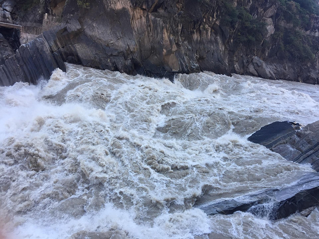 虎跳峡水流湍急,确实很震撼很壮观,河流中间有几块大石,可能是山体