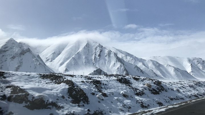 冰天雪地里居然有一个人在向我们挥手,大哥慢慢把车停靠在路边.