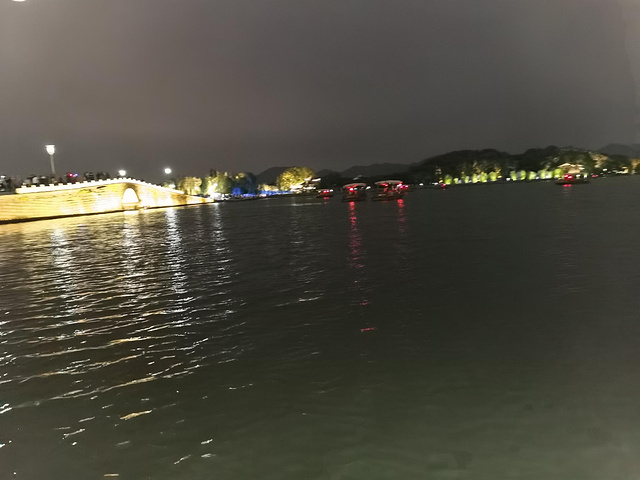 杭州西湖的夜晚不错啊.小朋友自己开船.对面是雷峰塔吧
