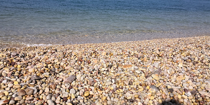 月牙湾的海滩不是沙子而是天然的鹅卵石被海浪冲刷得非常光滑可惜不能