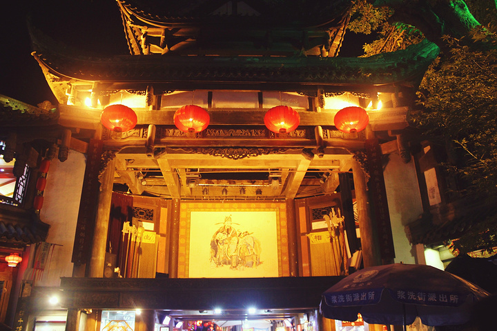 的小哥一边摆出好玩的姿势一边招揽着客人合影,一边的皮影戏摊子上