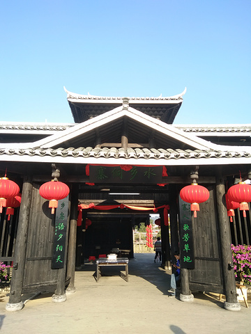 过寨伺水乡这个牌匾下的门时,需要和过寨酒,那个木桌上放着的就是过寨