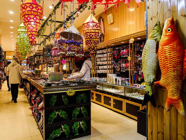 晚上灯火通明游人也很多非常繁华热闹有些摊位还装饰得非常有民族特色